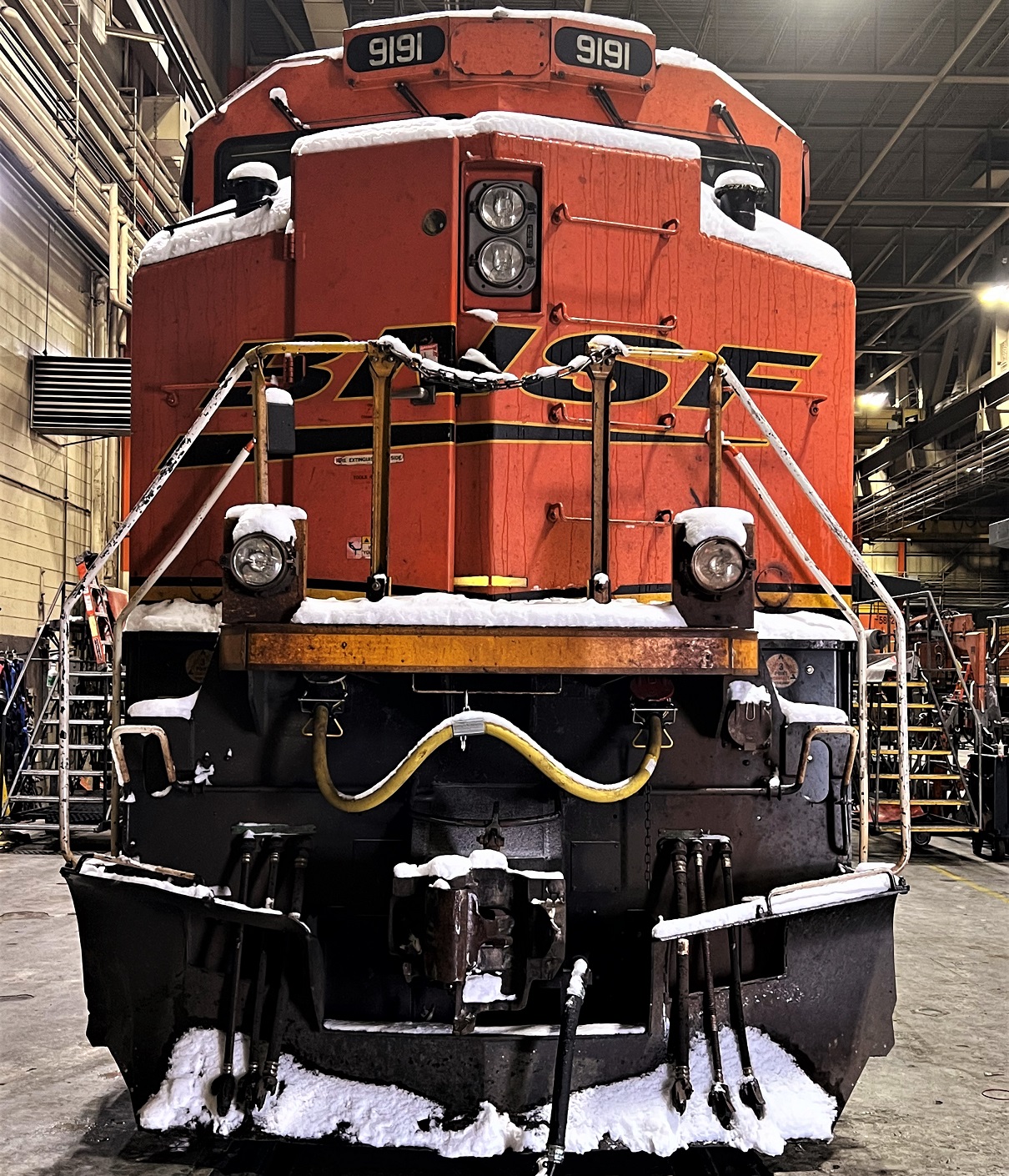 Front of a BNSF Locomotive. The picture was takin inside a maintenance building.