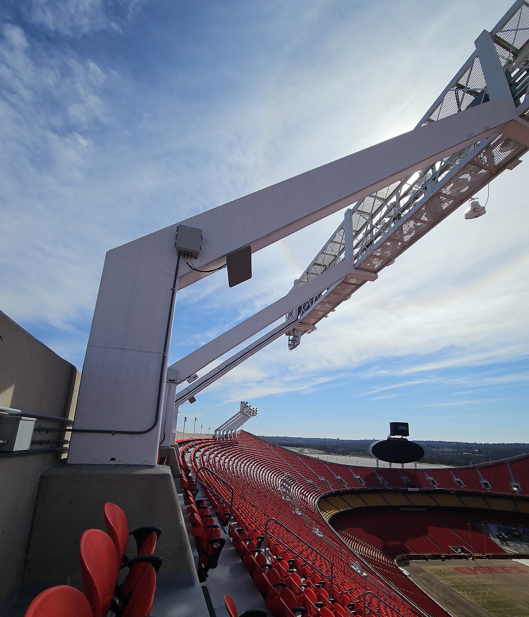 A view of Arrowhead stadium from the top. The images looks towards the east. A sea of bright red seats split by a band of yellow seats fill the lower half of the picture. A little less than half of the playing field is visible. Two of the light stations are along the left side at the top of the stadium bowl.