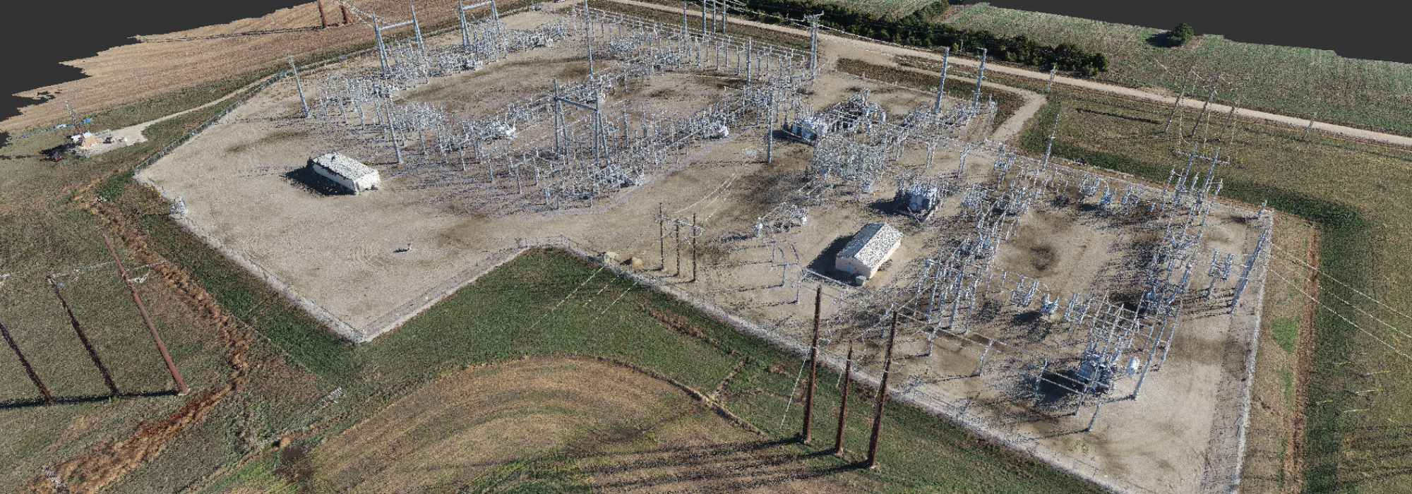 A 3D point cloud in isometric aerial view of an electrical substation surrounded by agricultural land, showing intricate details of power transmission infrastructure and surrounding landscape.