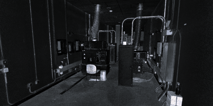 A black-and-white point cloud representation of a projection room, showcasing detailed 3D spatial data of equipment, ducts, and various structures. The scene includes projection equipment, ventilation pipes, and wiring, with visible depth and geometry.